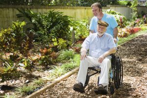 Senior in garden with caregiver