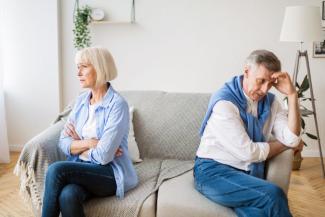 Elderly couple on couch facing away from eachother