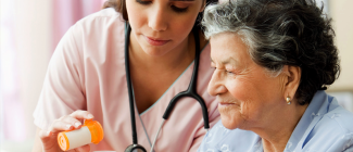 Nurse giving medication to senior at retirement home