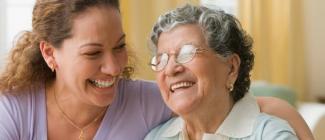 Caregiver smiling at elderly female
