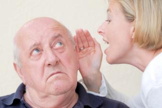 Care worker speaking to senior with hearing loss