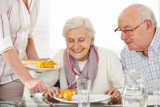 Elderly couple being served lunch