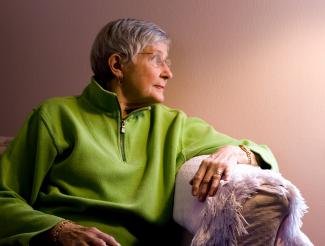 Older woman with green sweater on couch