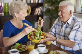 Elderly couple enjoying a salad together
