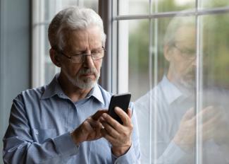 Male with glasses looking at phone