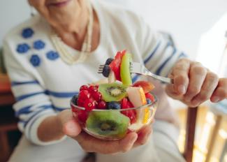 Senior woman with bowl of fruit