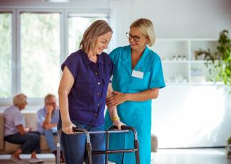 Nurse assisting senior with walker