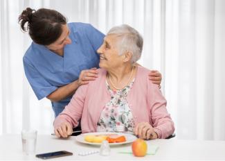 Caregiver helping senior eat a meal
