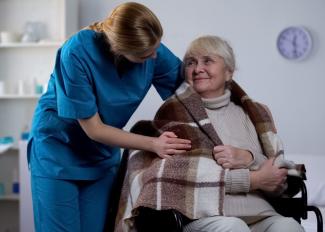 Caregiver helping senior stay warm