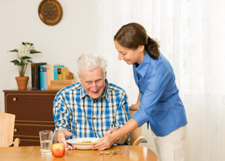 Caregiver providing a safe meal to a senior