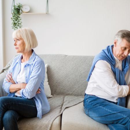 Elderly couple on couch facing away from eachother