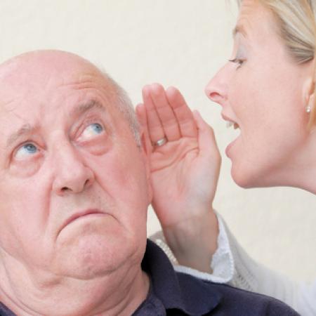 Care worker speaking to senior with hearing loss