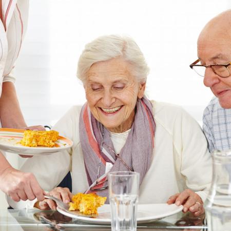 Elderly couple being served lunch