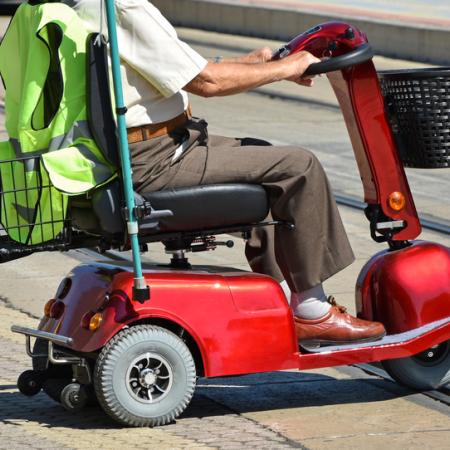 Senior male riding mobility scooter