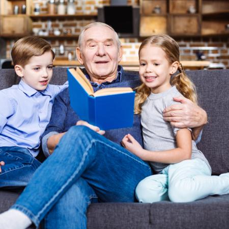 Grandfather reading to grandchildren