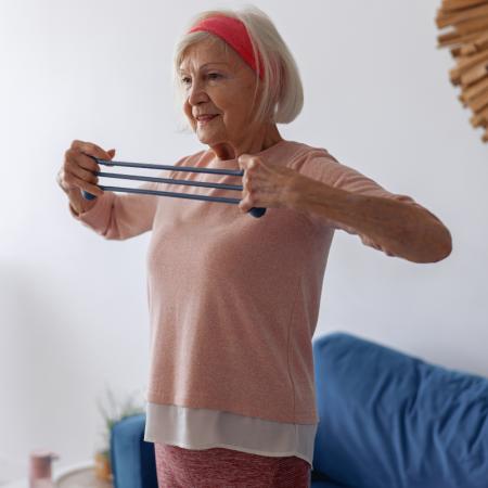 Senior woman working out at home to stay healthy and active during the winter season