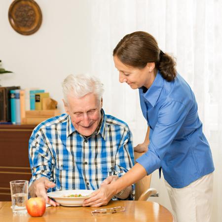 Caregiver providing a safe meal to a senior