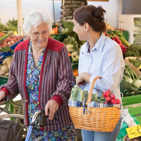 Caregiver grocery shopping with senior, ensuring they get healthy and nutritious ingredients for meals